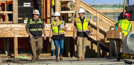 Three CBG workers walking on construction site.